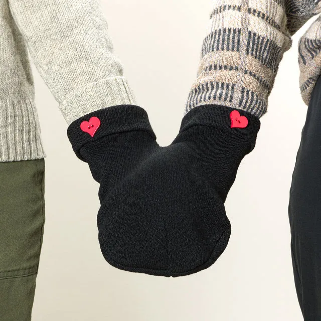 Hand holding gloves by Smitten Mittens